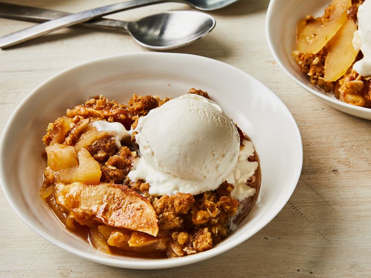 A bowl of apple crisp with vanilla ice cream